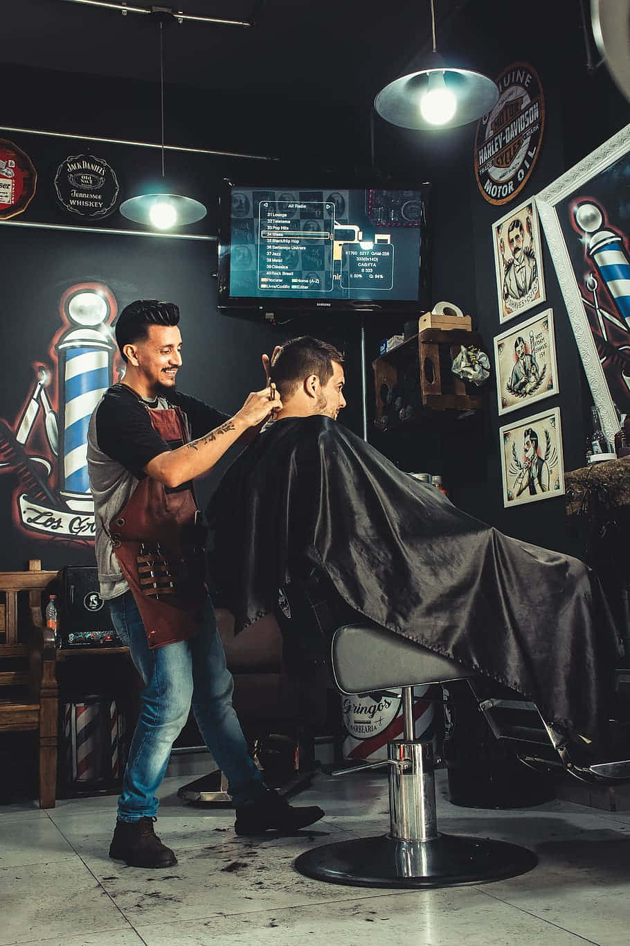 Barbero atendiendo a un cliente en el interior de Barbería La Hermandad